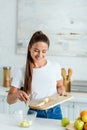 Girl putting sliced banana in glass bowl near fruits Royalty Free Stock Photo