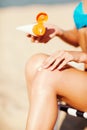 Girl putting sun protection cream on beach chair Royalty Free Stock Photo