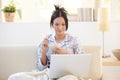 Girl in pyjama having cereal using laptop Royalty Free Stock Photo