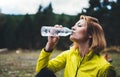 Girl quenches thirst after fitness, person drinking water from plastic bottles relax after exercising sport outdoors, woman isolat Royalty Free Stock Photo