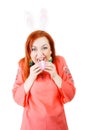 Girl with rabbit ears bitten egg, isolated. Royalty Free Stock Photo
