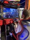 Woman driving a racing game. Girl on a racing car simulator. Concept: computer games, car racing. Kyiv, Galaxy amusement park,