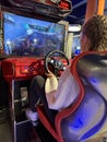 Woman driving a racing game. Girl on a racing car simulator. Concept: computer games, car racing. Kyiv, Galaxy amusement park, Royalty Free Stock Photo