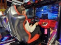 Woman driving a racing game. Girl on a racing car simulator. Concept: computer games, car racing. Kyiv, Galaxy amusement park, Royalty Free Stock Photo