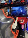 Woman driving a racing game. Girl on a racing car simulator. Concept: computer games, car racing. Kyiv, Galaxy amusement park,