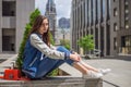 Girl in ragged jeans sits on the street