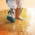 Girl in rain boots is standing in a puddle Royalty Free Stock Photo