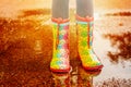 Girl in rain boots is standing in a puddle Royalty Free Stock Photo