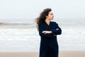 Girl rain sea wind winter portrait woman smile spring coat long hair curly mood shore snow beach Royalty Free Stock Photo