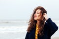 Girl rain sea wind winter portrait woman smile spring coat long hair curly mood shore snow beach Royalty Free Stock Photo