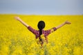 Girl with raised arms in yellow rapeseed field Royalty Free Stock Photo