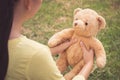 .The girl raised the brown teddy bear to look in the garden. And talk and play  After he received on his birthday Royalty Free Stock Photo