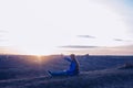 A girl with raised hands is praying. On the background of the sunset sky. Repentance for sins. Kneeling Prayer to God. Worship Royalty Free Stock Photo