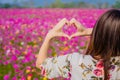 The girl raised her hand to display a meaningful heart-shaped symbol. Tell her that I love you on the blurred background of the