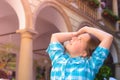 The girl raises her arms admiringly and looks behind the head at the sunlight