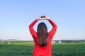 The girl raises her hand to display a meaningful heart-shaped symbol. Tell her that I love you on the blurred background of the