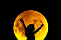 Girl raising hands up on a background full moon