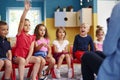 Girl raising her hand to ask question in classroom