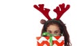 A sweet girl hides behind a Christmas gift box