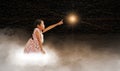 A girl reaching for the star, sitting on a cloud in dark sky, night time. Concepts of fulfilling your dream, wish, goal, and doing Royalty Free Stock Photo