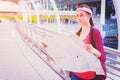 A girl read map in town.A lone girl red bag holding map and searching road to house Royalty Free Stock Photo