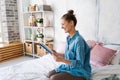 Girl reading book in bed, lying on her stomach, smiling happy and relaxed Royalty Free Stock Photo