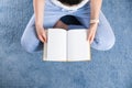 Girl reading book at cozy home. Girl smiling and petting furry cat Royalty Free Stock Photo