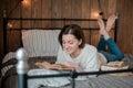 Girl reading a book and drinking coffee in bed feet on the wall. Royalty Free Stock Photo