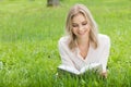 Girl reading book on grass Royalty Free Stock Photo