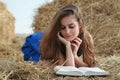 Girl reading book on hay Royalty Free Stock Photo