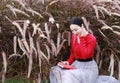 Girl reading the book and listening to the music . Blonde beautiful young woman with book sit on the grass. Outdoor. Sunny day Royalty Free Stock Photo