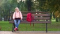 Girl reading book, sitting on bench in park, doing homework outdoors, study Royalty Free Stock Photo