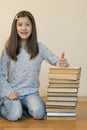 Girl reading a book sitting on the floor in an apartment. Cute girl reading book at home. education and school concept - little Royalty Free Stock Photo