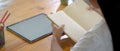 A girl reading book to doing her homework on wooden worktable with mock-up tablet Royalty Free Stock Photo