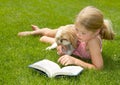 Girl reading with dog outdoors Royalty Free Stock Photo