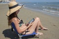 Girl reading ebook on the beach Royalty Free Stock Photo