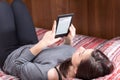 Girl is reading with an Ebook Reader on the bed Royalty Free Stock Photo