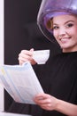 Girl reading magazine drinking coffee. Hairdryer in hair beauty salon Royalty Free Stock Photo