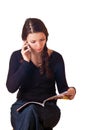 Girl reading magazine and talking by phone. Royalty Free Stock Photo