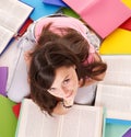 Girl reading pile colored book.