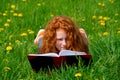 Girl is reading in spring meadow Royalty Free Stock Photo