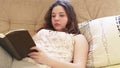 Girl reads bestseller book on comfy sofa