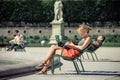 The girl reads the book in the Tuileries garden