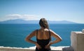 Girl from rear enjoying view of the sea