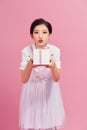 Girl received a gift. Girl blows a kiss. Portrait, pink background