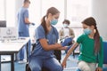 Girl Receiving Coronavirus Vaccine Injection Sitting With Doctor Indoor Royalty Free Stock Photo