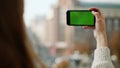 Girl recording video smartphone green screen outdoors. Woman using mock up phone Royalty Free Stock Photo