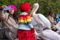 Girl in red beret interacts with colourful pelicans with long beaks in St James's Park, London UK.