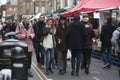 Girl in red beret and man with long hair in black hat dressed in cool Londoner style walking in Brick lane, a street popular among Royalty Free Stock Photo