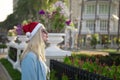 Girl in a red Christmas hat next to the swimming pool with blue water. Holiday concept. Royalty Free Stock Photo